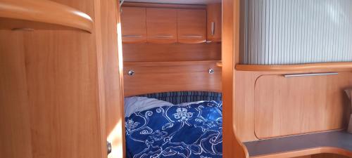 een kast met houten kasten en een bed erin bij Caravan Finca La Vida Rustica in Maella