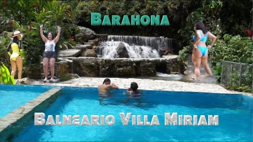 a group of people in a swimming pool next to a waterfall at Villa in Santa Cruz de Barahona