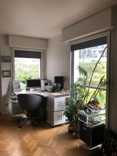 an office with a desk with a computer and a plant at JO 2024 Bel APPARTEMENT DANS UN ECO QUARTIER ANIME PROCHE METRO TRAM ET TOUR EIFFEL in Boulogne-Billancourt