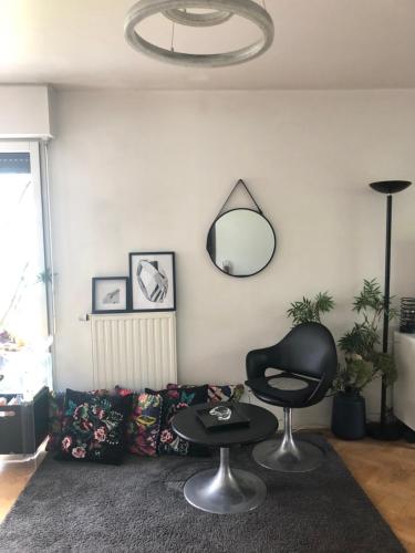 a living room with a couch and a mirror at JO 2024 Bel APPARTEMENT DANS UN ECO QUARTIER ANIME PROCHE METRO TRAM ET TOUR EIFFEL in Boulogne-Billancourt