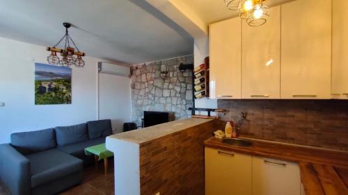 a kitchen and a living room with a blue couch at Fortress Sofranac in Cetinje