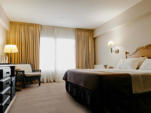 a hotel room with a bed and a window at Wyndham Garden Ushuaia Hotel del Glaciar in Ushuaia