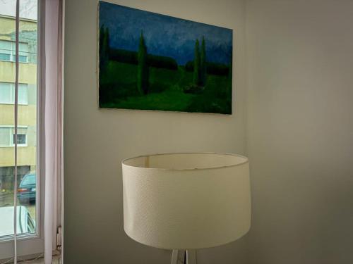 une lampe dans une pièce avec un tableau sur le mur dans l'établissement Mirror Apartment, à Novi Pazar