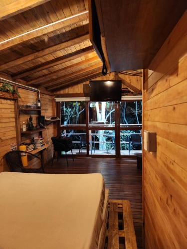 a bedroom with a bed in a room with wooden walls at Cabaña en Medio del Bosque con Jacuzzi - Santa Elena in Santa Elena