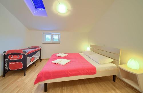 um pequeno quarto com uma cama com um cobertor vermelho em Nette Wohnung in Šilo mit Möblierter Terrasse em Šilo