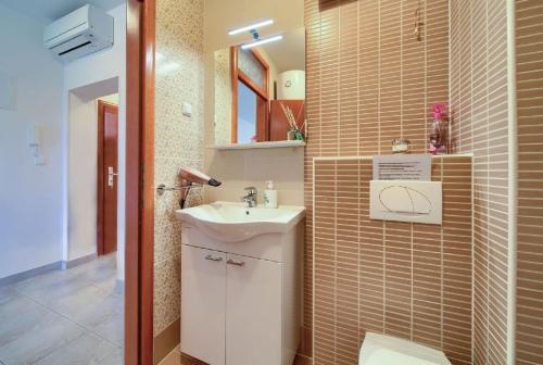 uma casa de banho com um lavatório e um WC em Nette Wohnung in Šilo mit Möblierter Terrasse em Šilo