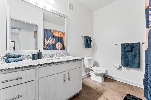 Baño blanco con lavabo y aseo en Charming Oasis 10 Min to Parks Pets Allowed en Orlando