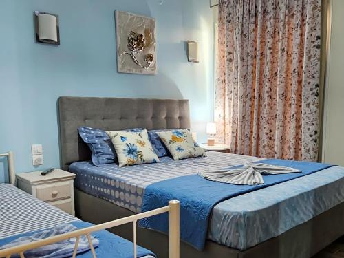 a bedroom with two beds with blue walls at HARA APARTMENT In Front Of The Beach in Paralia Katerinis