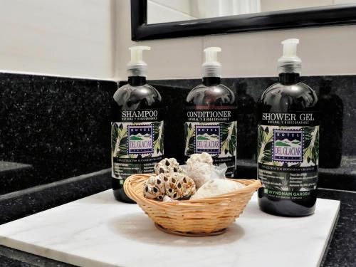 three bottles of whiskey and a basket of mushrooms on a counter at Wyndham Garden Ushuaia Hotel del Glaciar in Ushuaia