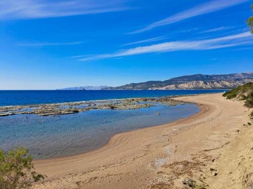 a beach with mountains in the background at Arancio independent room in Ecovilla on the beach in Apolakkiá
