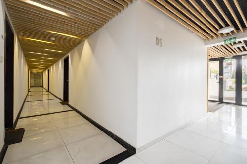 a hallway of a building with white walls and a wooden ceiling at Papini's Apartment -apartment with big terrace in Bucharest