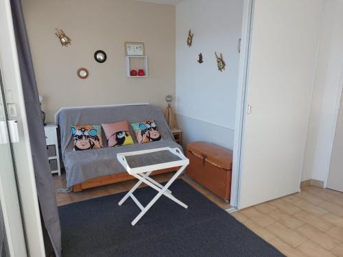 - une petite chambre avec un lit et un tabouret dans l'établissement Joli studio avec piscine à 200m de la plage parking privé, à La Grande Motte
