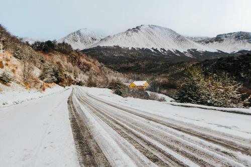 a snow covered road with mountains in the background at Wyndham Garden Ushuaia Hotel del Glaciar in Ushuaia