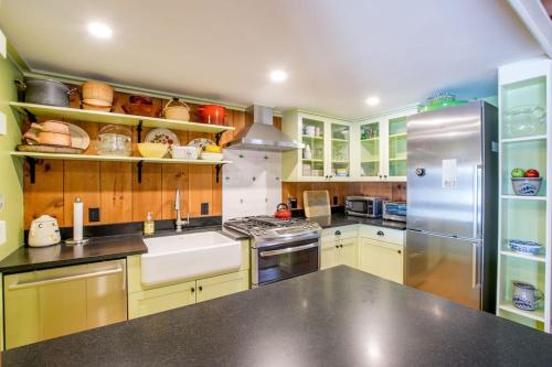 a kitchen with yellow cabinets and a stainless steel refrigerator at 10 ft from Crystal Lake New renovation in Orleans