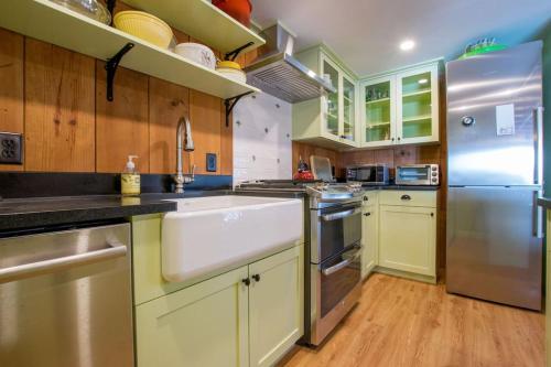 a kitchen with a sink and a refrigerator at 10 ft from Crystal Lake New renovation in Orleans