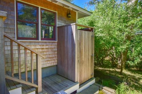 a house with a wooden door and stairs on it at 10 ft from Crystal Lake New renovation in Orleans