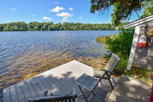 two chairs sitting on a dock next to a lake at 10 ft from Crystal Lake New renovation in Orleans