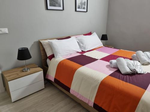 a bedroom with a bed with a colorful blanket and a night stand at Cà Fiamma in Casale Monferrato