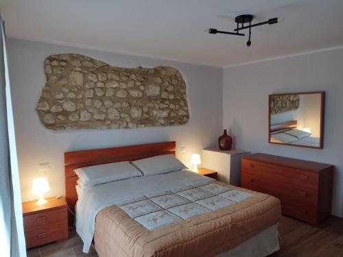 a bedroom with a bed and two lamps and a stone wall at Casa Vacanza "Marinella" in Sulmona