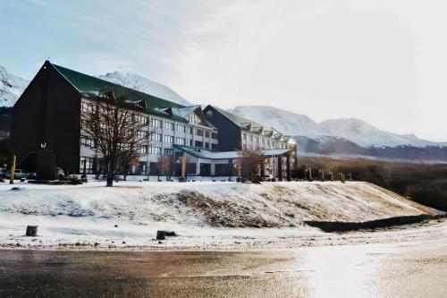 a hotel in the snow with mountains in the background at Wyndham Garden Ushuaia Hotel del Glaciar in Ushuaia