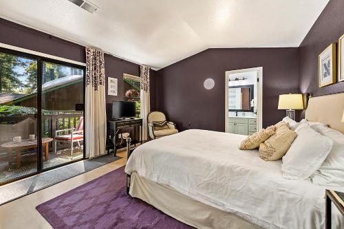 a bedroom with a large bed and a balcony at Camp Ciyole in Guerneville