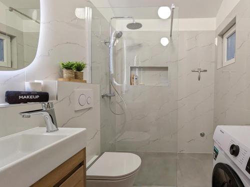 a bathroom with a shower and a toilet and a sink at Poolside Studio in Fažana