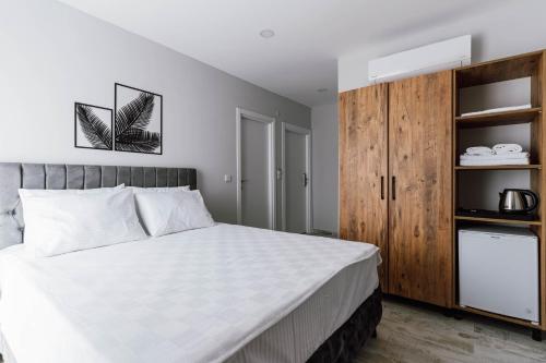 1 dormitorio con 1 cama y armario de madera en The Han YK Hotel, en Avcılar