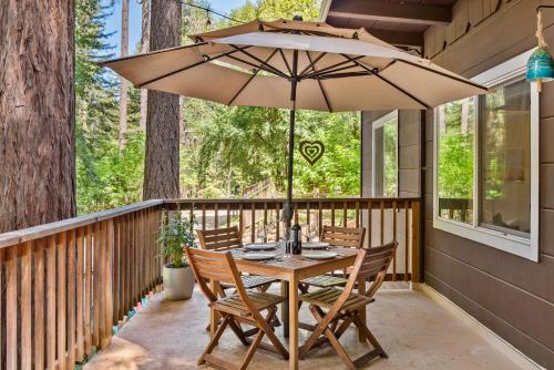 a table and chairs on a porch with an umbrella at Faeya Grove in Forestville