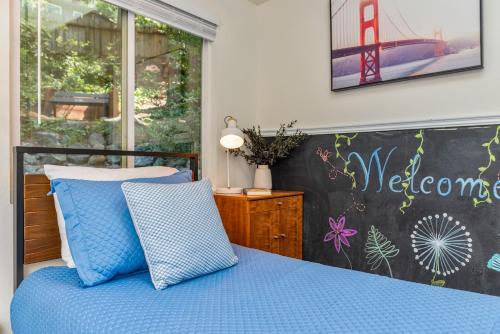 a bedroom with a blue bed with a welcome wall at Faeya Grove in Forestville