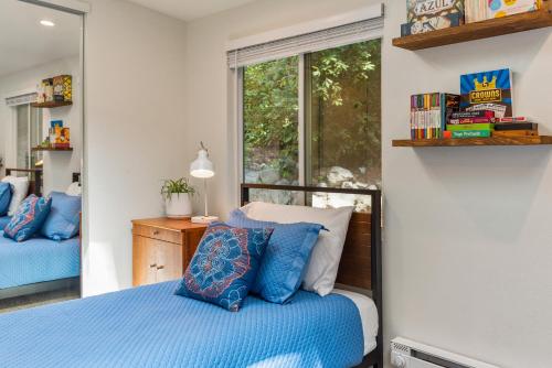 a bedroom with a bed with blue pillows and a window at Faeya Grove in Forestville