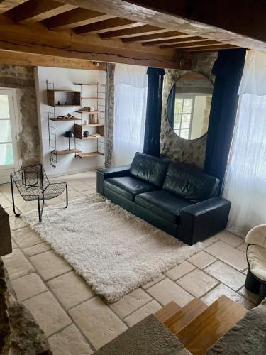 - un salon avec un canapé noir et un tapis dans l'établissement gite seccotine, à Saint-Mard-de-Vaux