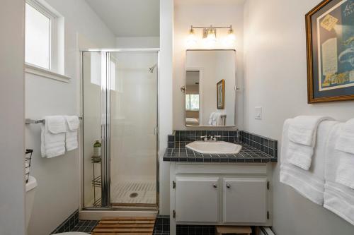 La salle de bains blanche est pourvue d'un lavabo et d'une douche. dans l'établissement Five Oaks, à Forestville
