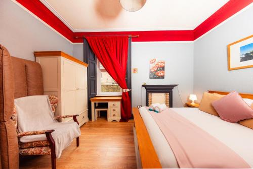 a bedroom with a bed and a chair and a fireplace at Warm, Cozy&Relaxed Apartment by Holyrood Palace in Edinburgh