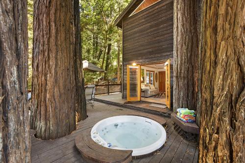 a bath tub sitting on a deck next to a tree at Willowhaven in Monte Rio