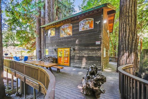 a wooden deck with a cabin in the trees at Willowhaven in Monte Rio