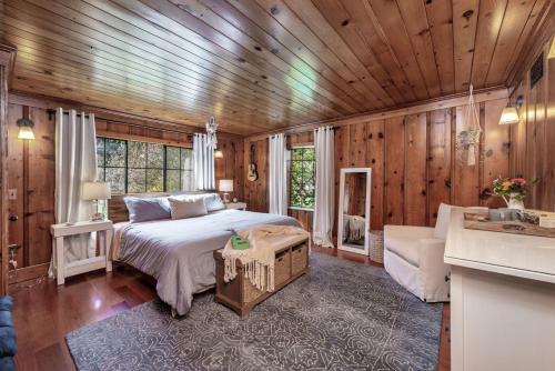 een slaapkamer met een bed in een kamer met houten wanden bij Rivendell in Monte Rio