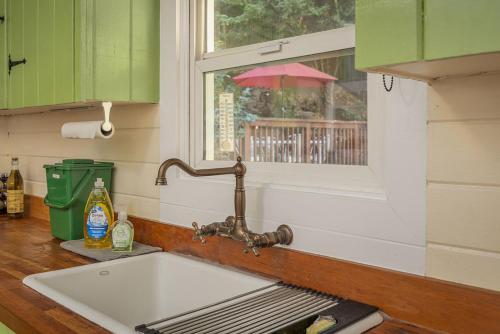 a kitchen with a sink and a window with an umbrella at Salmon House in Guerneville