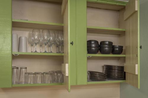 a green cabinet with wine glasses and plates in it at Salmon House in Guerneville