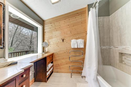 ein Badezimmer mit Dusche, Badewanne und Waschbecken in der Unterkunft Spacious Maggie Valley Cabin with Waterfall On-Site! in Maggie Valley