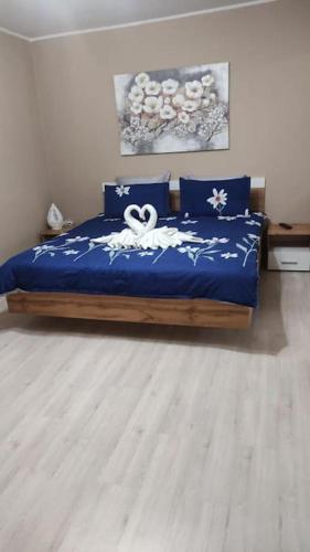 a bedroom with a bed with a blue comforter at Apartament in centrul istoric in Baia Mare