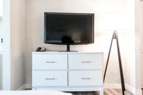 a tv sitting on top of a white dresser at Perry's Ocean-Edge Resort in Daytona Beach