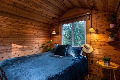 Un dormitorio con una cama en una habitación de madera. en Rocktop Lodge, en Forestville