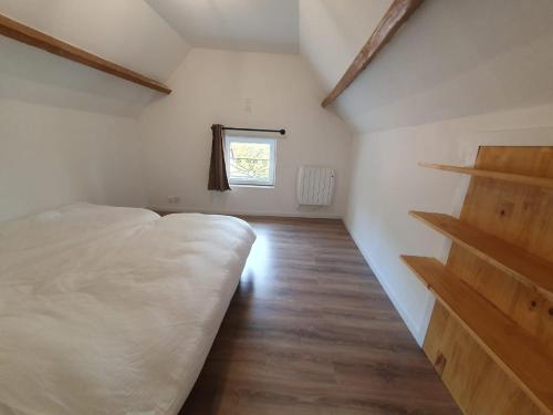 une chambre avec un lit blanc et une fenêtre dans l'établissement Maison village calme, Douai à 10min., à Goeulzin