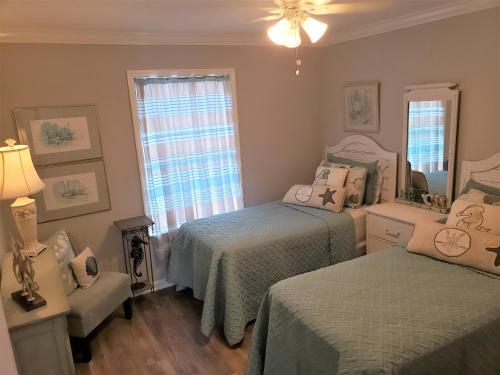 a bedroom with two beds and a window at Jubilee Landing 107 in Orange Beach