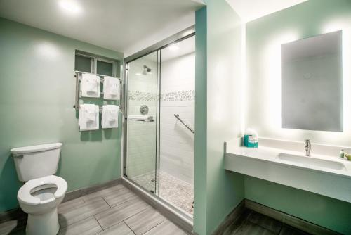 a bathroom with a toilet and a sink and a shower at Perry's Ocean-Edge Resort in Daytona Beach