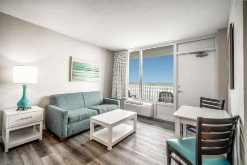 a living room with a couch and a table at Perry's Ocean-Edge Resort in Daytona Beach
