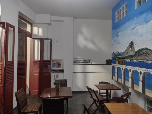 um restaurante com mesas e cadeiras e um quadro na parede em Arcos Da Lapa Hostel no Rio de Janeiro