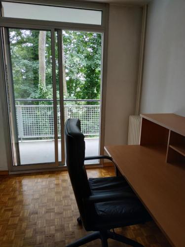 um escritório com uma secretária, uma cadeira e uma janela em Spacious Condo, Green Serenity em Palaiseau