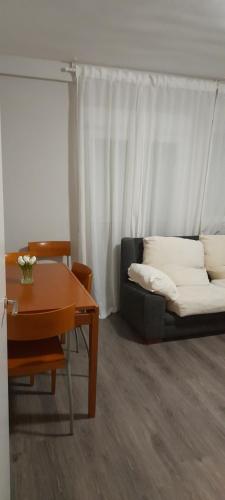uma sala de estar com um sofá e uma mesa em Casa francisca em Arroyo de la Encomienda