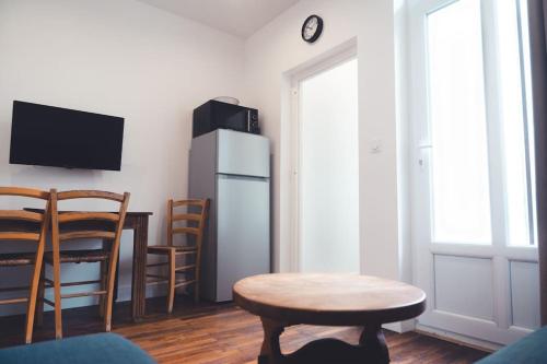 un salon avec une table et un réfrigérateur dans l'établissement Le Sauvignon, T2 de caractère avec jardin, à Tours